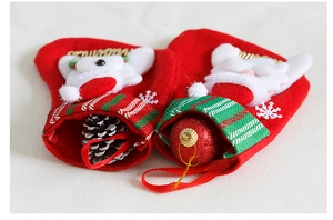Dettaglio di calze natalizie rosse con figure di Babbo Natale e orso con ricami di fiocchi