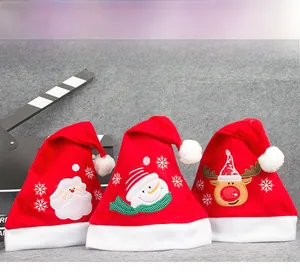 Detailaufnahmen der Stickerei von Weihnachtsmann, Schneemann und Rentier auf Plüschmützen