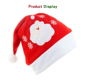 Detail von gesticktem Weihnachtsmann und Schneeflocke auf einer roten Plüsch-Weihnachtsmütze