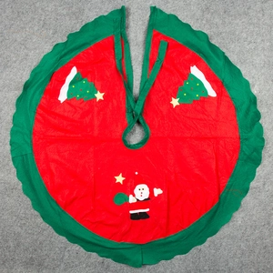 Red Christmas tree skirt with green ruffle edge and festive Santa Claus applique