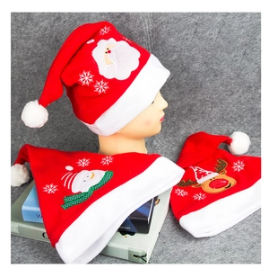 Nahaufnahme von Samt-Weihnachtsmützen mit Stickereien von Weihnachtsmann und Rentier