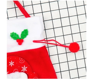 Close-up of red velvet Christmas gift stocking with white snowflake prints and drawstrings