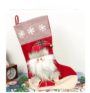 Detail of plush Santa Claus stocking with snowflake patterns and red plaid hat