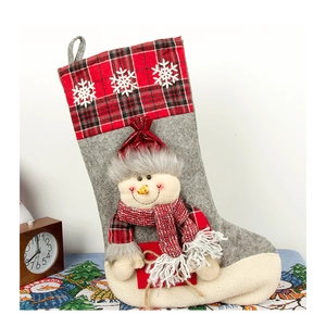 Detail of Christmas stocking featuring a 3D snowman, red plaid cuff, and snowflake embroidery