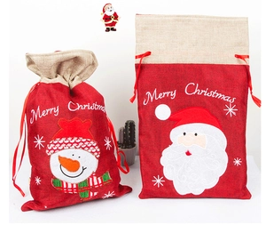 Detail van kerstcadeauzakjes van jute met borduursels van de Kerstman en een sneeuwpop