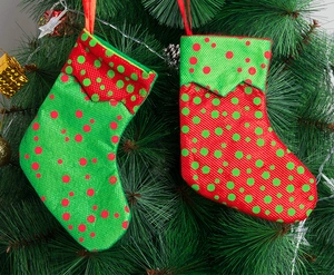 Detail of red and green polka dot Christmas stocking ornaments hanging on a festive tree