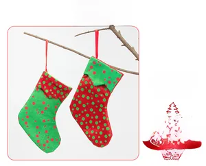 Detail of red and green polka dot Christmas elf stockings hanging on a branch