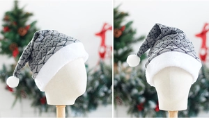 Detail of grey knitted Christmas hat with plush white trim and fluffy pompom ornament