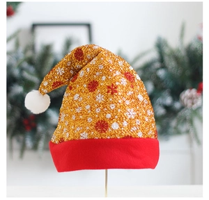 Dettaglio del cappello di Natale in paillettes dorate con bordo rosso e fiocchi di neve