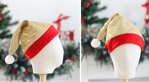 Detail of red mesh Christmas hat with gold glitter spirals and white pompom topper