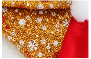 Dettaglio del tessuto glitter con fiocchi di neve e pompon bianco su cappello natalizio