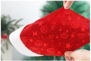 Close-up of red mesh Christmas hat fabric with star patterns and plush velvet trim