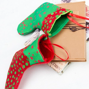 Set of two red and green polka dot Christmas stocking gift bags with ribbon handles
