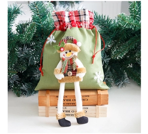 Detail of Christmas snowman gift bag with long legs and drawstring on pine branch