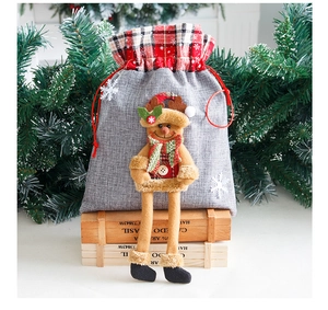 Detail of Christmas burlap gift bag with 3D reindeer doll and red drawstring closure