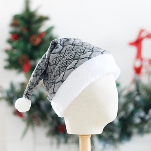 Plush Christmas hat with gray knit pattern and white faux fur trim on festive background