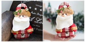 Detail of Santa Claus fabric gift bag with red plaid cotton and small metal bells