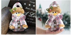 Detailed view of checkered snowman gift bag with plush hat and tiny bell for Christmas