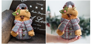 Detail of plush reindeer gift bag with bells and plaid fabric for Christmas decor