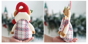 Detail of Christmas plush doll with red plaid fabric, festive hat, and bell pendant
