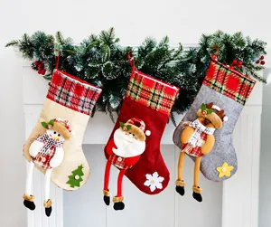 Three burlap Christmas stockings with 3D long-legged plush figures hanging on white fireplace