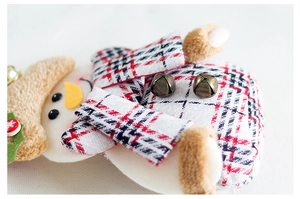 Detail of Christmas snowman plush with red plaid fabric, faux fur trim and bronze bells
