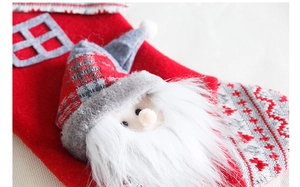 Detailopname van een rode vilten kerstsok met een 3D-kerstman en lange pluche baard