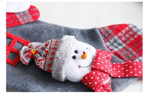 Detail van kerstsok met 3D pluche sneeuwpop en rood-grijs geruite stoffen decoratiedetail