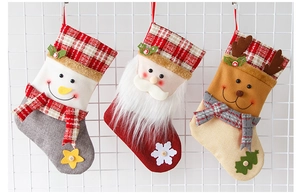 Vue détaillée de trois chaussettes de Noël suspendues en lin avec motifs Père Noël, bonhomme de neige
