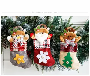 Three-piece burlap Christmas stockings set with Santa, Snowman and Reindeer hanging on branch