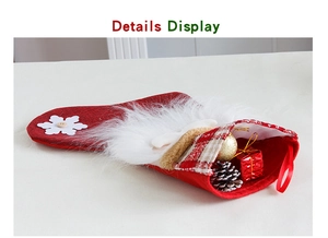 Détail de chaussette de Noël rouge avec bordure en fourrure, pommes de pin et boules