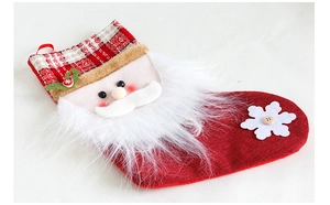 Détail d'une chaussette de Noël Père Noël avec barbe blanche et décorations de flocons