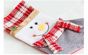 Vue détaillée d'une chaussette de Noël en lin avec visage de bonhomme de neige et plaid
