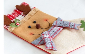 Détail de chaussette de Noël en lin avec motif renne, écharpe à carreaux et bois en peluche