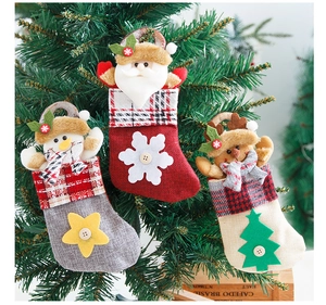 Close-up of three mini burlap Christmas stockings with Santa Snowman and Reindeer decor