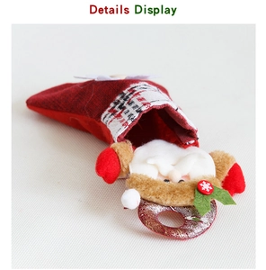 Detail of red mesh Christmas stocking with plush Santa Claus and plaid cuff design