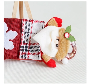 Close-up of burlap Christmas stocking featuring a 3D Santa doll and snowflake details
