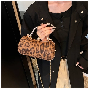 Detail of leopard print cylinder clutch bag with golden metal handle and crystal clasp
