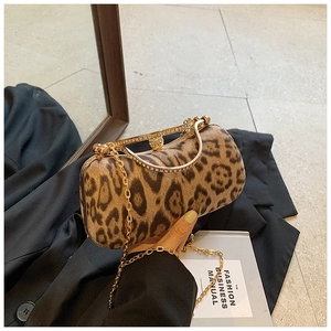 Detail of leopard print evening clutch with rhinestone handle and golden chain strap