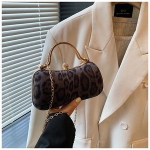 Close-up of leopard print clutch with gold metal handle and luxury faux fur texture