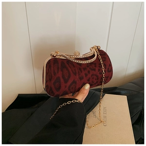 Close-up of burgundy leopard print velvet clutch with a sparkling rhinestone ball clasp