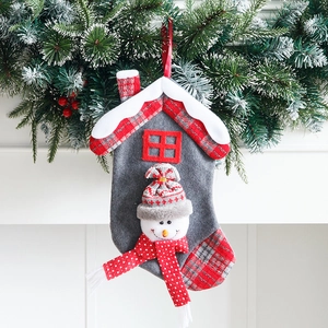 Kerstsok met huisontwerp met vilt sneeuwpop ornament en dennentakken decoratie