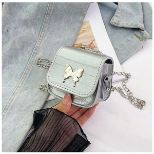 Detalle de un mini bolso de silla plateado metalizado con mariposa y cadena fina