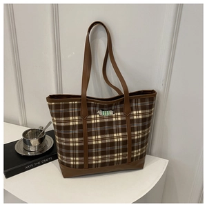 Detail of dachshund embroidery on brown checkered canvas tote bag with leather strap