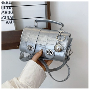 Detailed view of silver metallic mini bag with eel skin texture and double turn-lock design