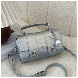Detailed view of silver metallic bag with eel-pattern texture and twin turn-lock closures