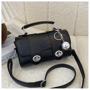 Detailed view of black textured handbag with silver twist locks and sphere charm