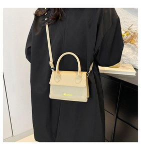 Detailed view of beige crossbody bag with litchi texture and fashion lettering