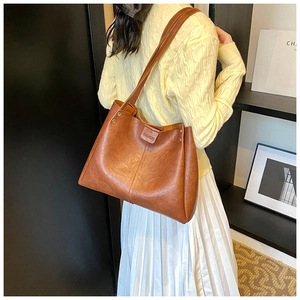 Brown vintage PU leather tote bag shown on shoulder for capacity and style reference
