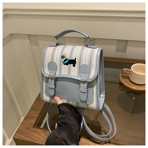 Close-up of sky blue striped canvas backpack with cartoon dog embroidery and buckle detail